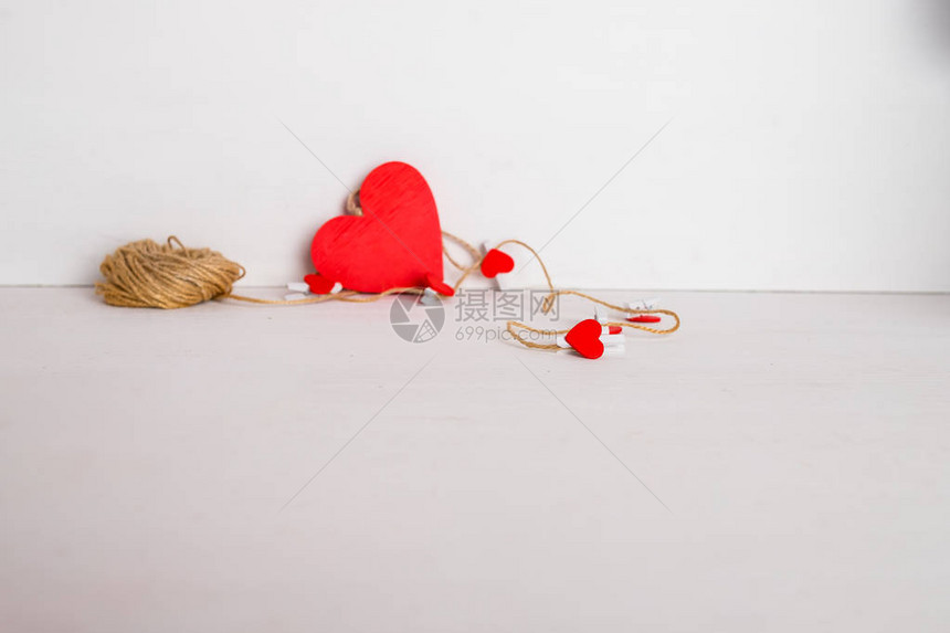 有心的衣夹挂在彩色背景上的绳子上情人节或其他爱情事件的最小风格的节日概念下面有一图片