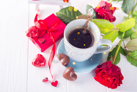 情人节和假日概念心形巧克力糖果咖啡杯和红玫瑰图片