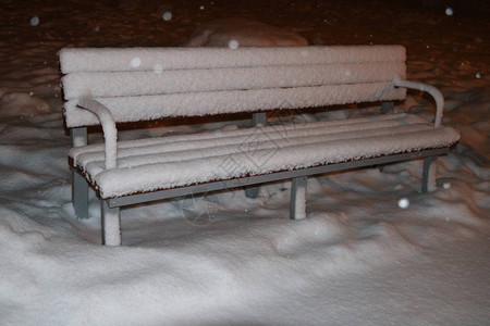 晚上公园的白雪覆盖的长凳图片