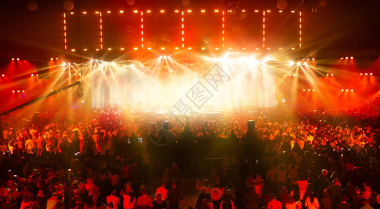 音乐会人群在摇滚音乐会上玩得开心带有大舞台的大型音乐厅很多人雷电设备电视用几台摄像机拍背景图片