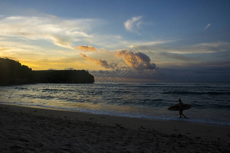 刺线沙滩的景色与冲浪者及阴云的日图片