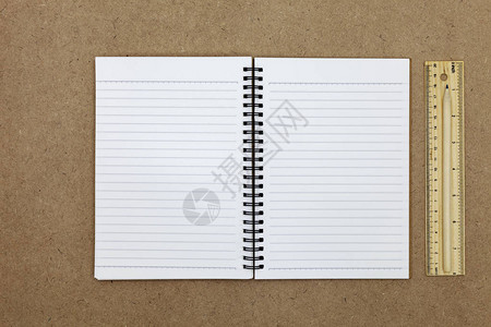 棕色纸背景上的空白笔记本图片