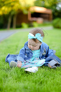 小天主教女婴坐在绿草上图片