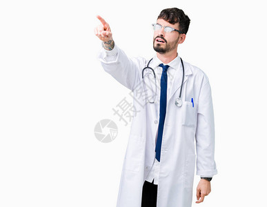 身穿医院外套的年轻医生在孤立的背景下用手指着前方图片