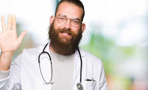金发大胡子穿医服的年轻金黄色医生男子以欢喜和笑容友图片