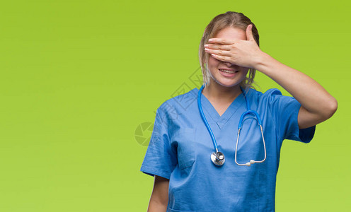 身穿外科医生制服的年轻白人医生女人在孤立的背景下微笑着图片