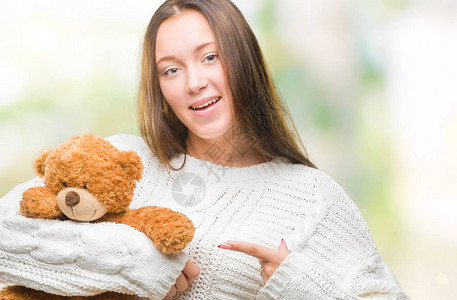 年轻caucasian年轻的女人拿着泰迪熊图片