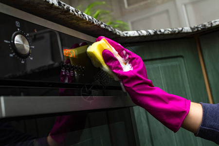 家庭主妇手拿橡胶手套在厨房用洗涤剂和图片
