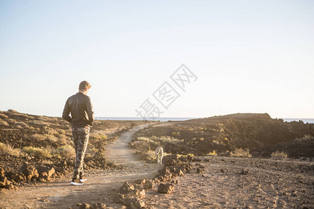 的人和最好的朋友狗一起走在户外沙漠休闲活动的小路上图片