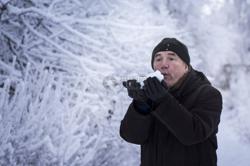 一个男人被白雪的枝子环绕着吹图片