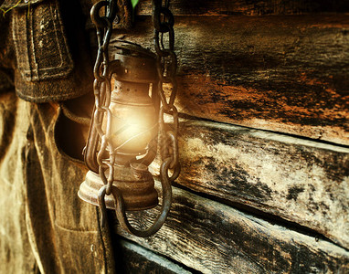 老式木制背景上的老式照明煤油灯背景图片