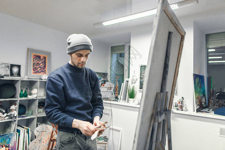 一位年轻艺术家的画像是在画架附近的工作室里图片