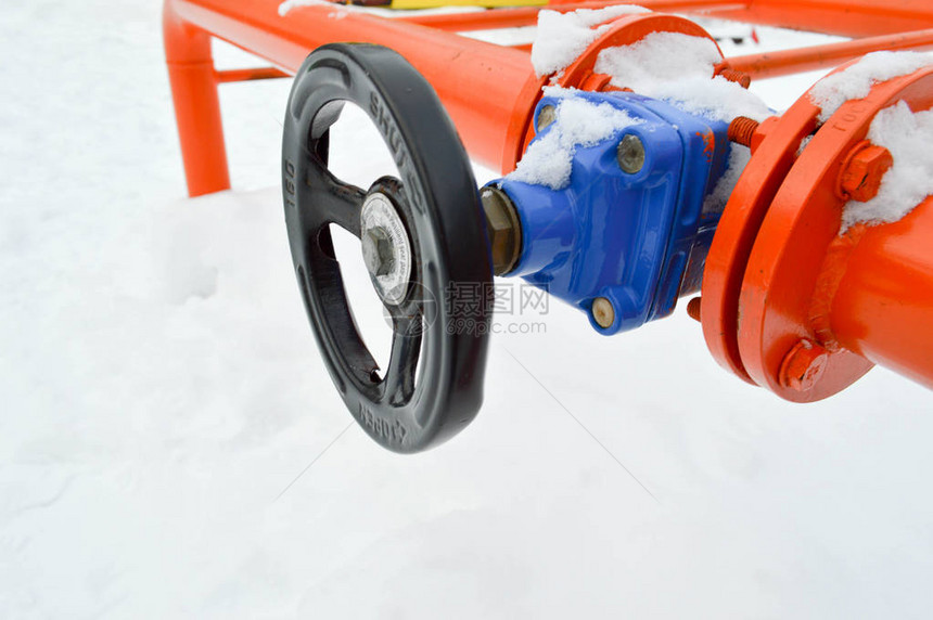 工业切断调节保护管件用于在冬季白雪背景下打开关闭带有法兰螺柱螺母的铁橙色金属图片