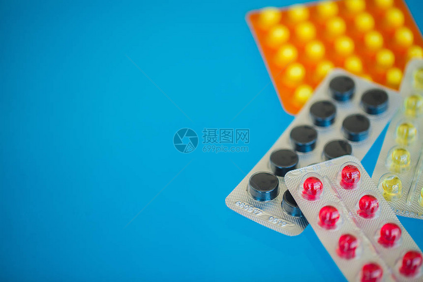 医疗丸蓝色背景上的彩色药丸和胶囊药房主题图片