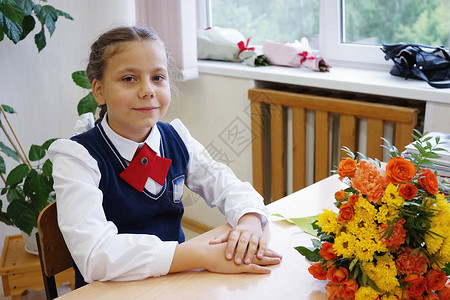 可爱的女学生坐在她的课桌旁上课图片