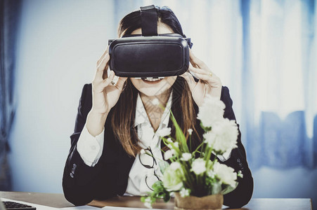 女商人使用VR耳机与虚拟现实一起工作图片