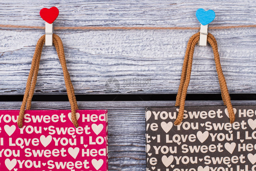 装有浪漫模式的纸袋挂在绳子上的固定礼品袋和心形衣物情人节礼物包图片