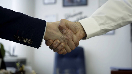 商业界人士以握手作为协议的标志接近于双方在办公室中保持了坚定的握手图片