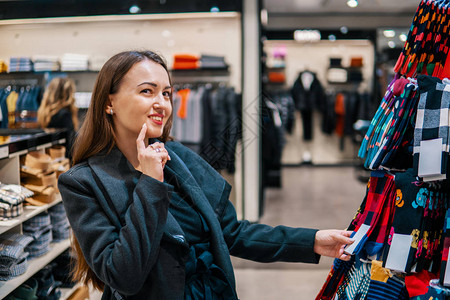 在商店超市商店寻找礼物的衣服的年轻美容少女图片