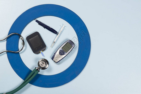 带有一些糖尿病设备的蓝色圆圈治疗疾病图片
