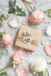 灰色背景中带玫瑰和小白花的礼品盒图片