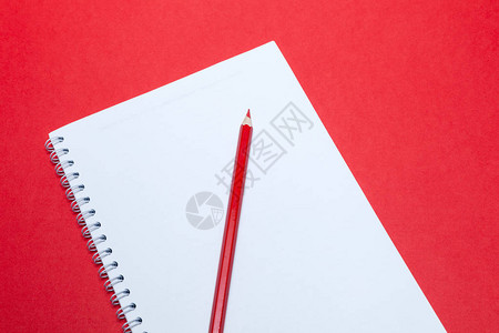 螺旋笔记本和黑色笔在空白纸上的白纸在红色背景上免费复印空间的概念商业书籍记事本日记用于艺术研讨会议课程背景图片