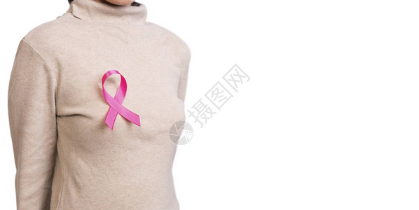 胸前系着粉红丝带的女人支持乳腺癌意识和国际妇女图片
