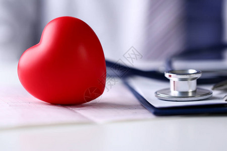 医用听诊器头和红色玩具心躺在心电图表特写上心脏治疗师脉冲图心脏物理心率测量心律失常911er背景图片