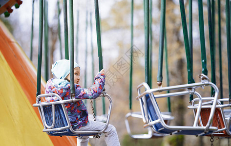 小孩骑在链式秋千上图片