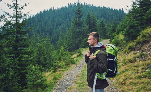男子背着沉重的背包在日落山上徒步旅行生活方式旅行癖冒险概念暑假独自图片