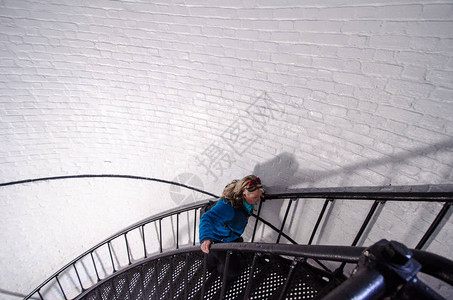 害怕身高的惊恐金发成年女子被扶着爬上螺旋楼梯在南卡罗来纳州狩图片
