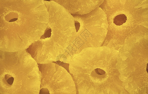 亮黄色蜜饯菠萝环背景特写背景图片