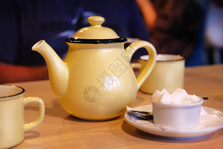 黄茶壶和咖啡桌上的杯子英图片