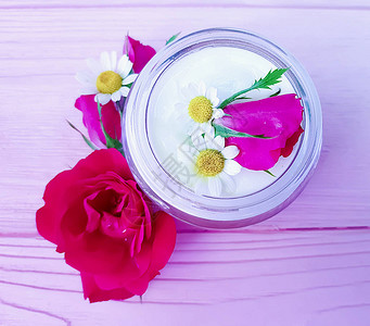 玫瑰花粉红色木质背景上的化妆品霜图片