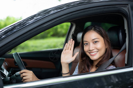 美丽的亚洲女在路上驾车旅行时笑图片