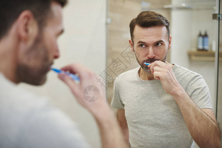 男人在浴室里清洁牙齿图片