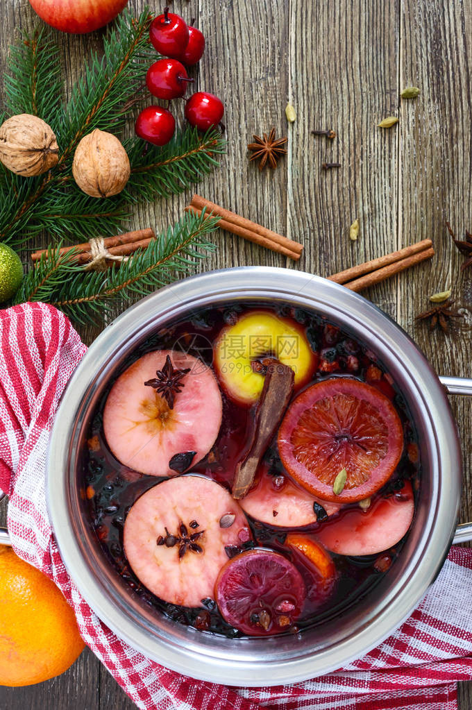 木桌上的大平底锅里放着热的甜酒基于葡萄酒果汁香料调味料水果的芳香传统冬季图片