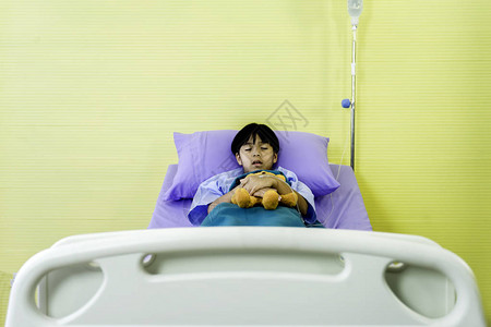 亚洲男孩患流感棕熊躺在病床上治图片