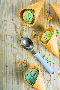 多彩姿的彩虹冰淇淋与木制背景上的冰淇淋锥图片
