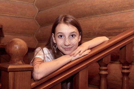 女孩靠在木屋里的木梯上图片