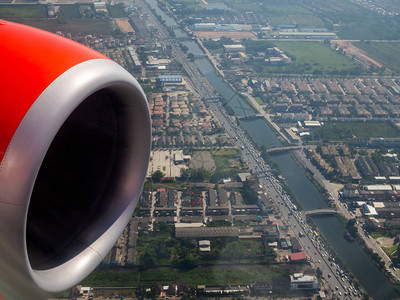 红色飞机的喷气机引擎和城市空中观望图片