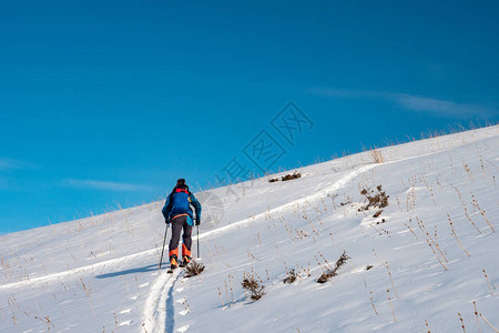 滑雪旅游一个人爬上山丘冬季运动图片