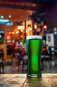 在酒吧的木制酒吧柜台一杯新鲜的冷绿色啤酒圣帕特图片