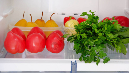 打开冰箱健康生素食黄瓜西红柿胡椒梨欧芹冰箱架子上的蔬图片