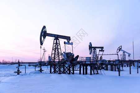 油田上的油泵千斤顶冬天日落天空背景石油的提图片