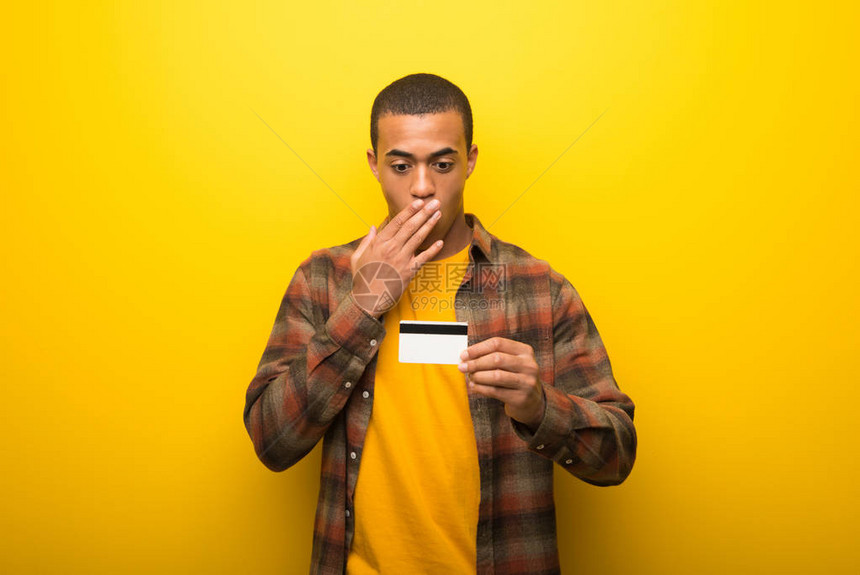 充满活力的黄色背景的年轻非洲裔美国人拿着信图片