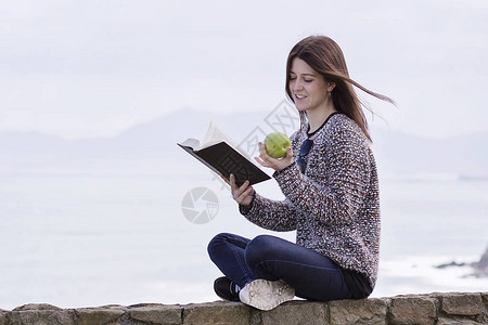 一个在海边休息和阅读的女孩图片