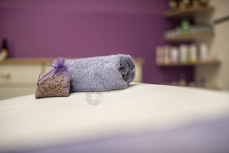 Spa和按摩概念滚动紫色毛巾裹着一小块熏衣草躺在化妆图片