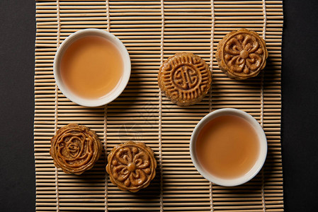 竹桌垫上传统月饼和茶杯的顶视图图片