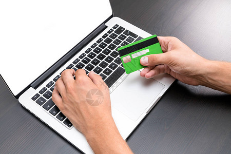 年轻的商人在键盘上输入信用卡信息信用卡在手可见关闭图片